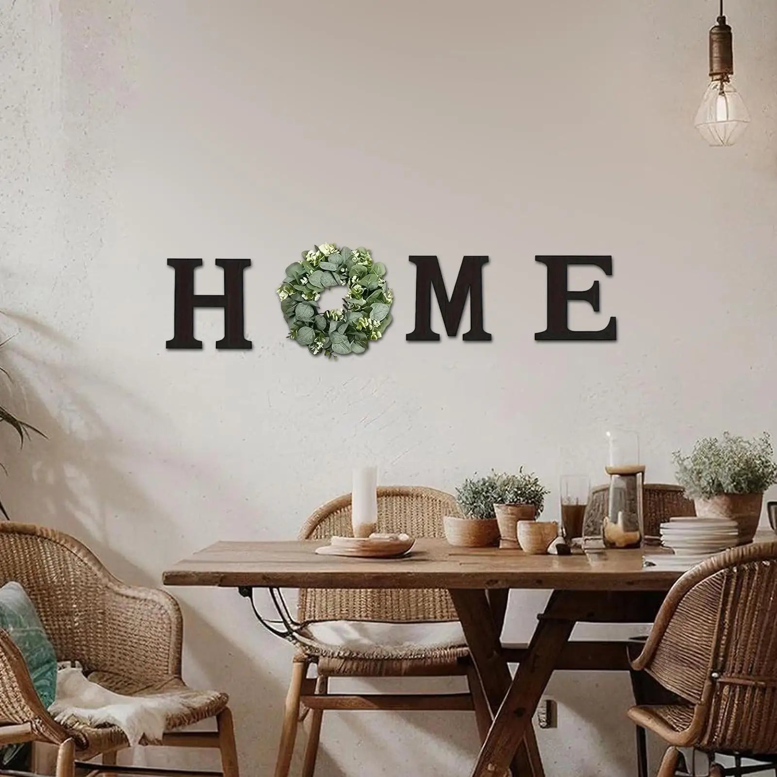Rustic black "HOME" wooden wall letters with a green artificial eucalyptus wreath replacing the letter O.