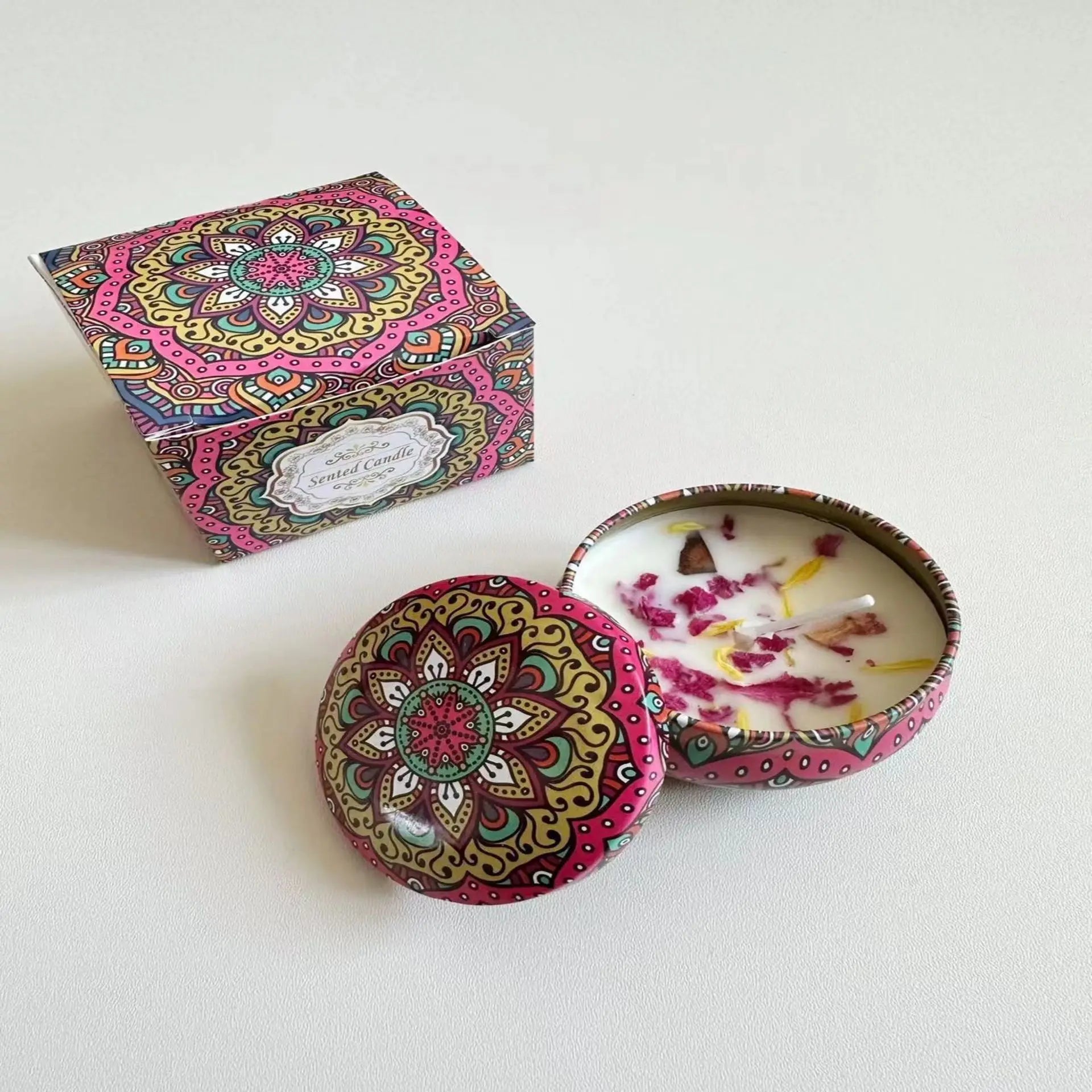 Scented candle in a colourful mandala-patterned tin with matching gift box, topped with decorative flower petals.
