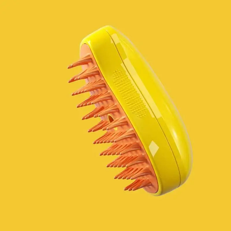 Bright yellow scalp massager brush with orange silicone bristles, set against a matching yellow background.