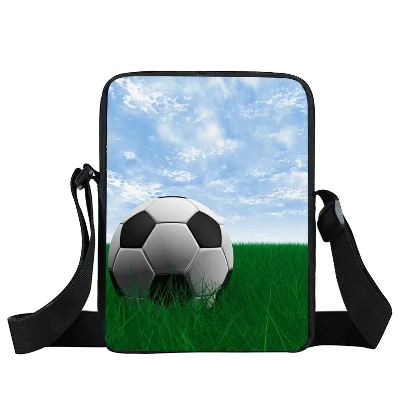 Small black shoulder bag featuring a printed football on a grass field under a blue sky.