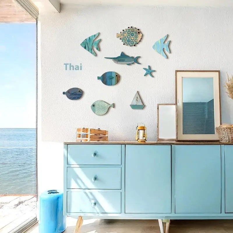 Set of 10 coastal-style wooden fish and nautical wall art pieces in varied blue tones, arranged on a white wall.
