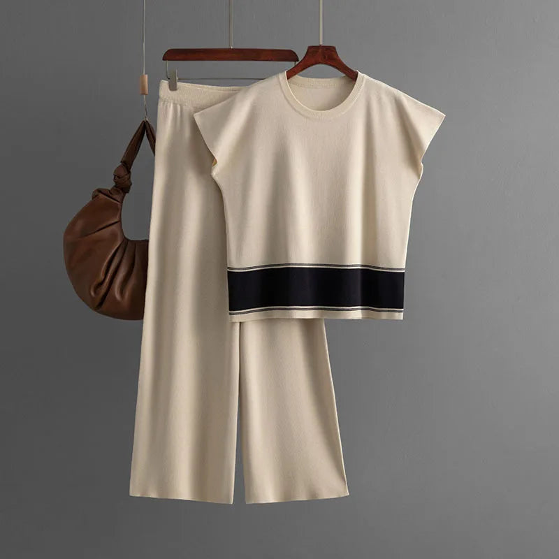 Cream knitted co-ord set with short-sleeved top featuring a black hem stripe and matching wide-leg trousers.