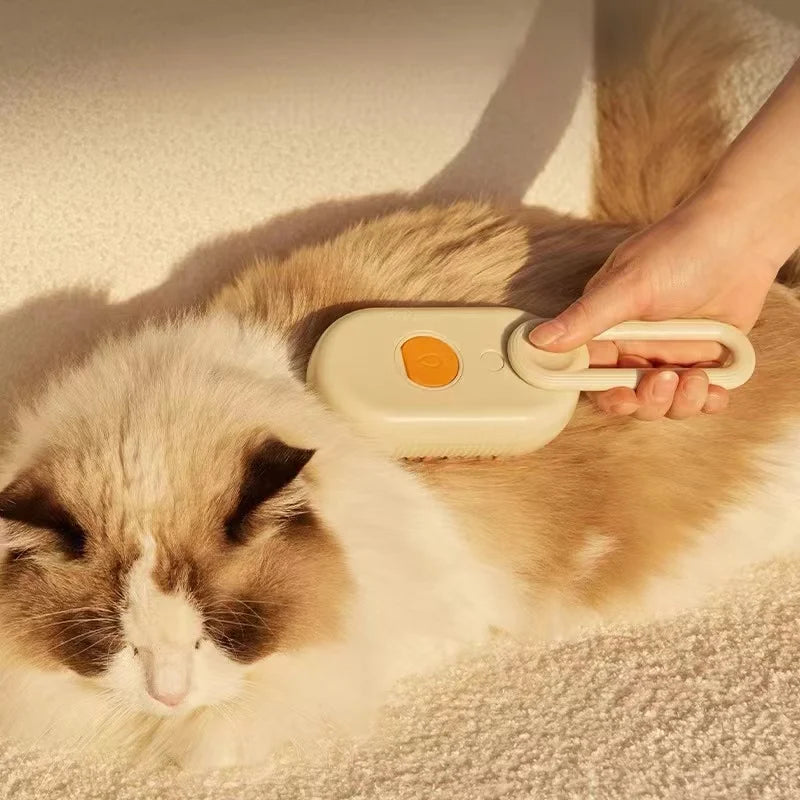 A person brushing a fluffy cat with a cream-coloured pet grooming tool featuring an orange push button.