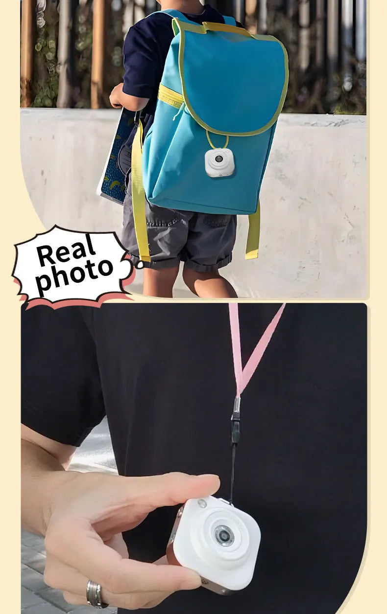 White square compact digital camera with a lens, shown on a child's blue backpack and hanging from a pink lanyard.