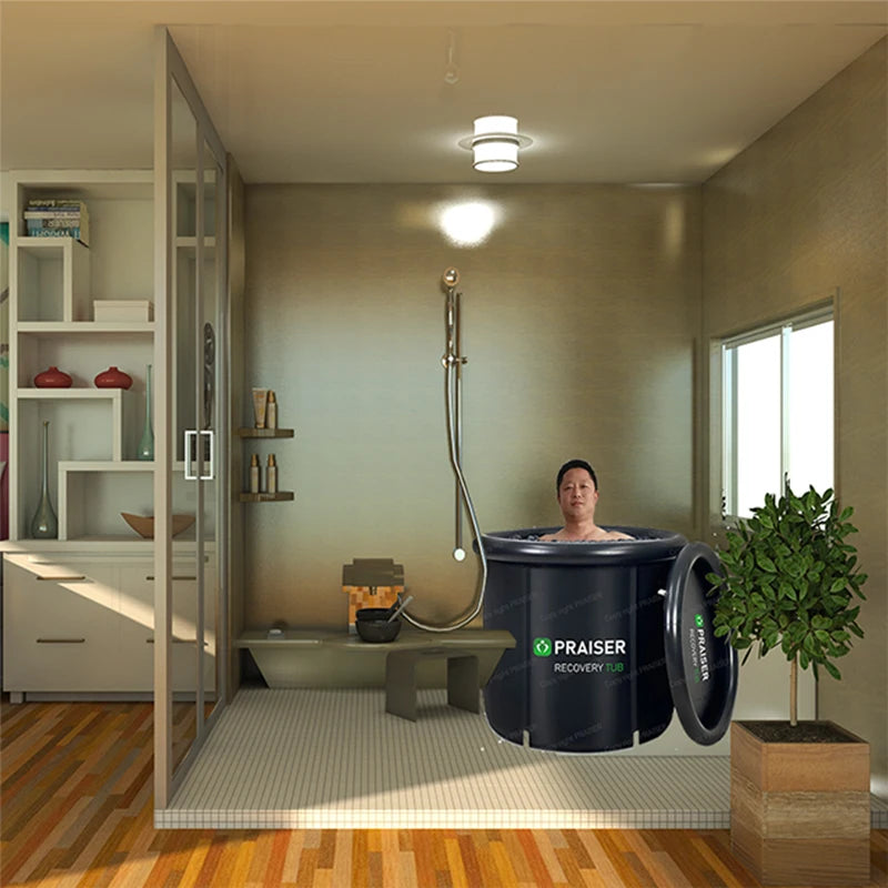 A man in a black round "PRAISER RECOVERY TUB" in a modern bathroom.