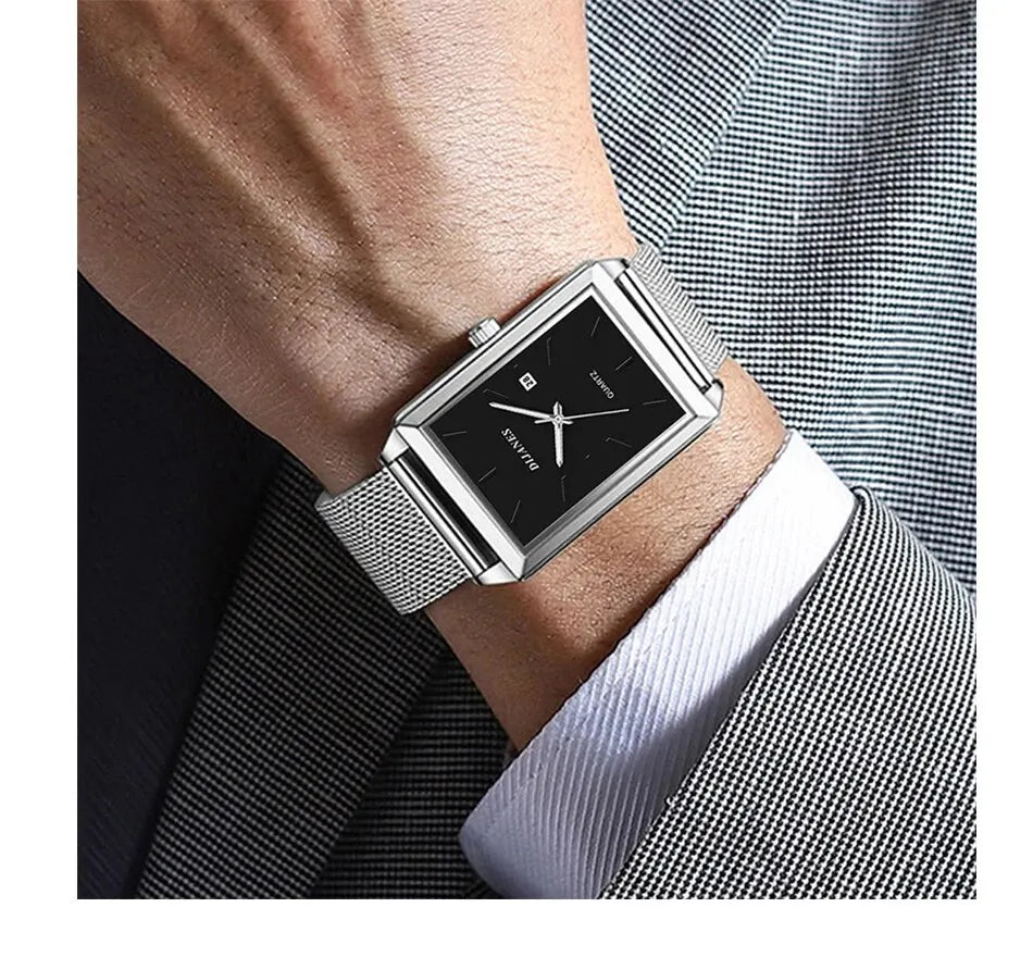 Men's rectangular stainless steel quartz watch with a black dial and silver mesh strap, worn on a suited wrist.