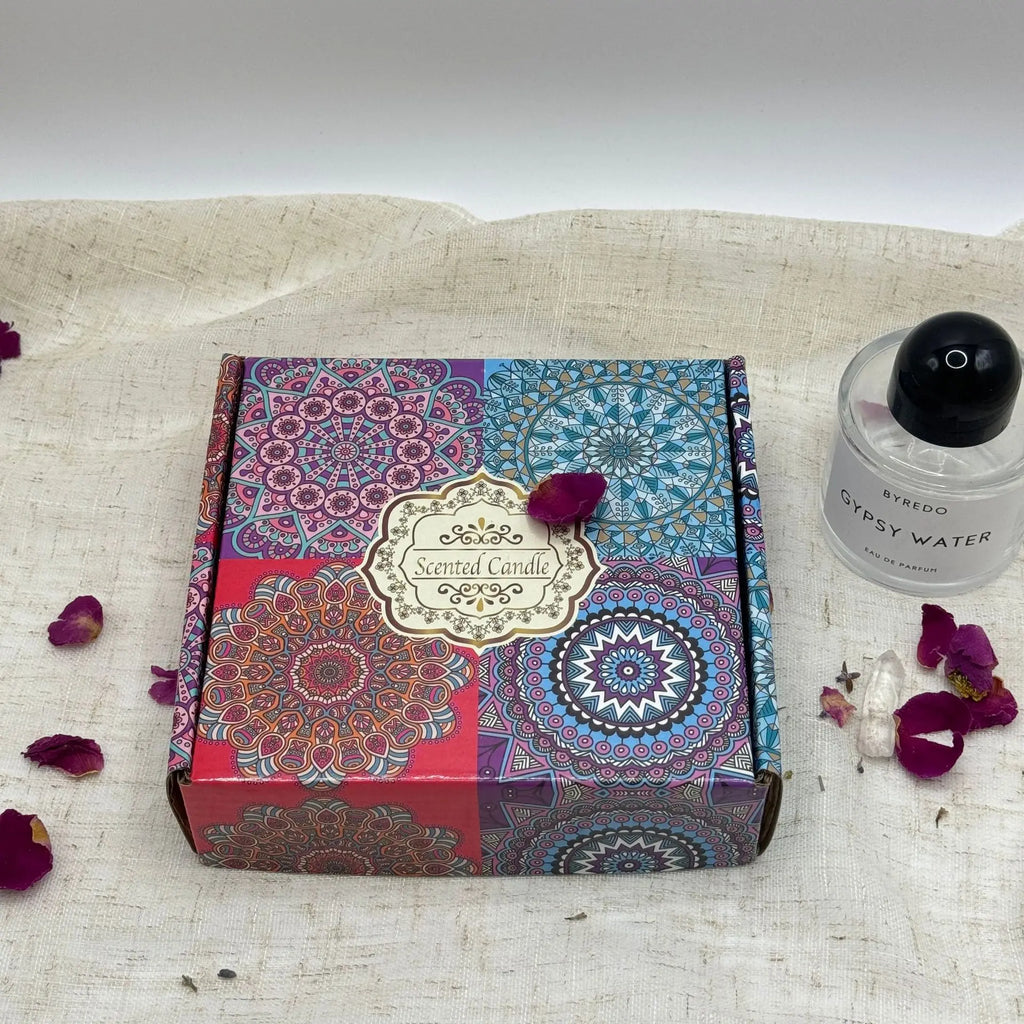 Square scented candle gift box featuring a colourful, intricate mandala pattern on a rustic linen background.