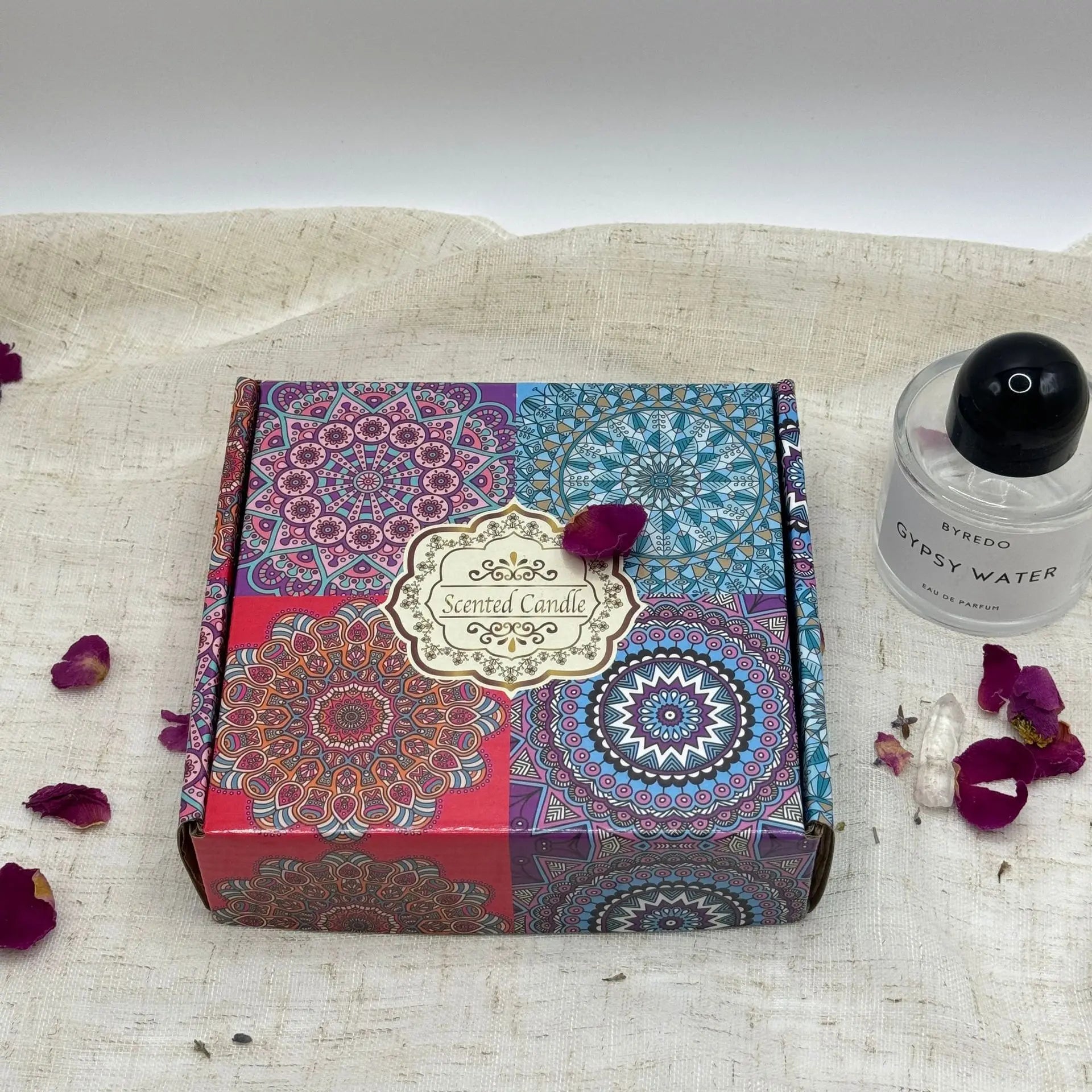 Square scented candle gift box featuring a colourful, intricate mandala pattern on a rustic linen background.
