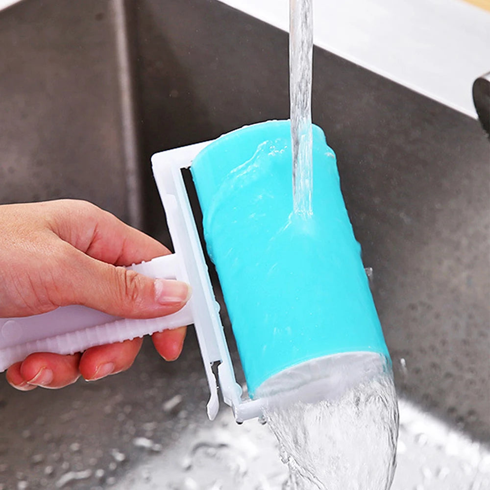 A hand rinses a reusable, bright blue sticky lint roller under a tap in a kitchen sink.