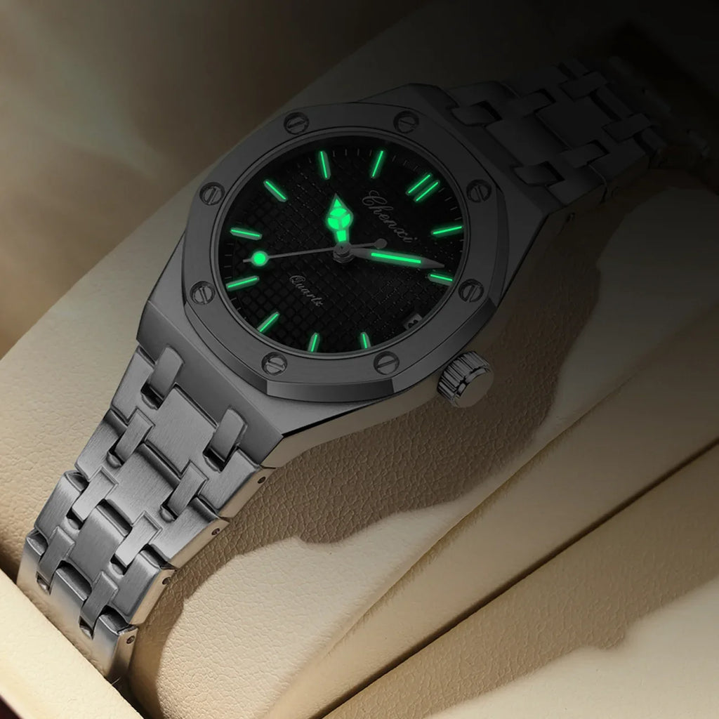 Luxury silver stainless steel women's analogue watch with a textured black dial and glowing hands and hour markers.
