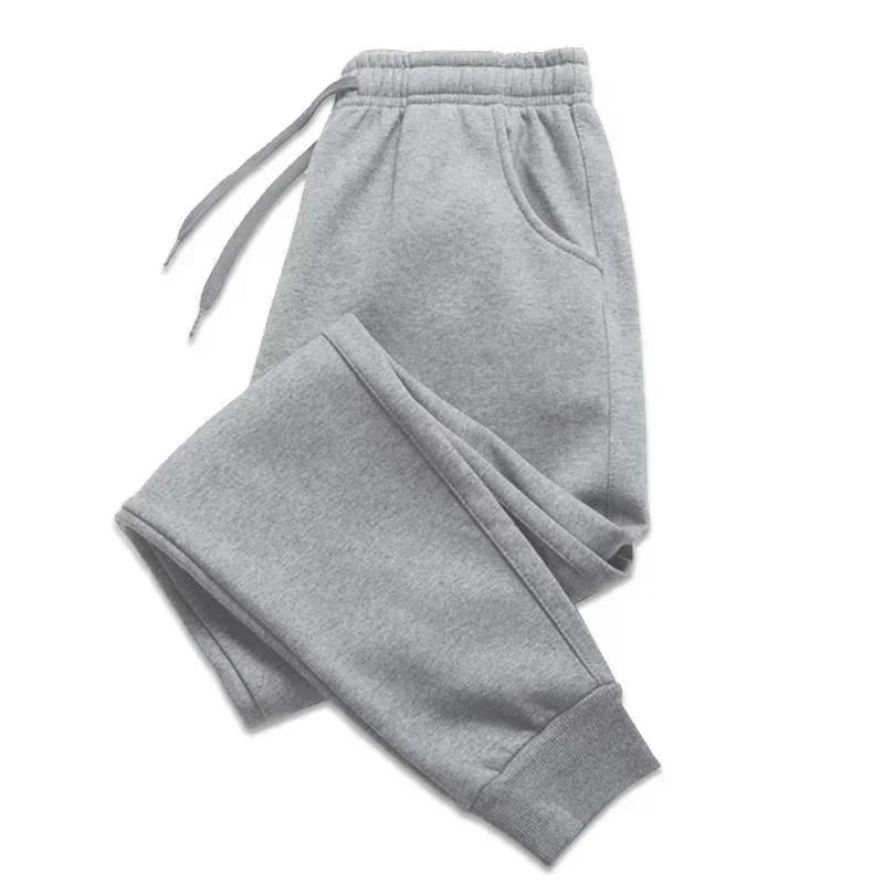 Light grey joggers with an elasticated drawstring waistband, side pockets, and cuffed ankles.