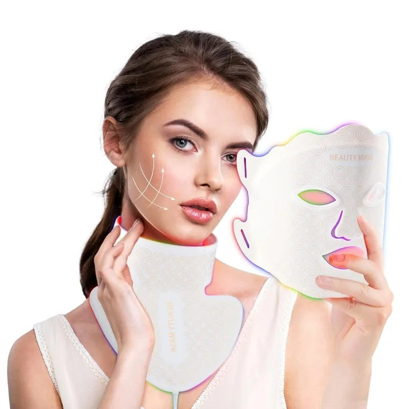 A woman holds a white LED face mask and wears a matching neck piece, both emitting a colorful glow.