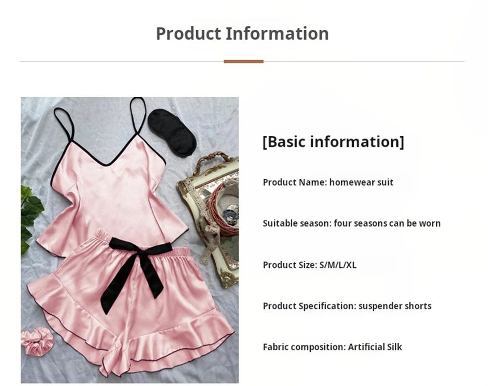 Pink satin camisole and ruffle-hem shorts set with black trim, a matching sleep mask, and a scrunchie.