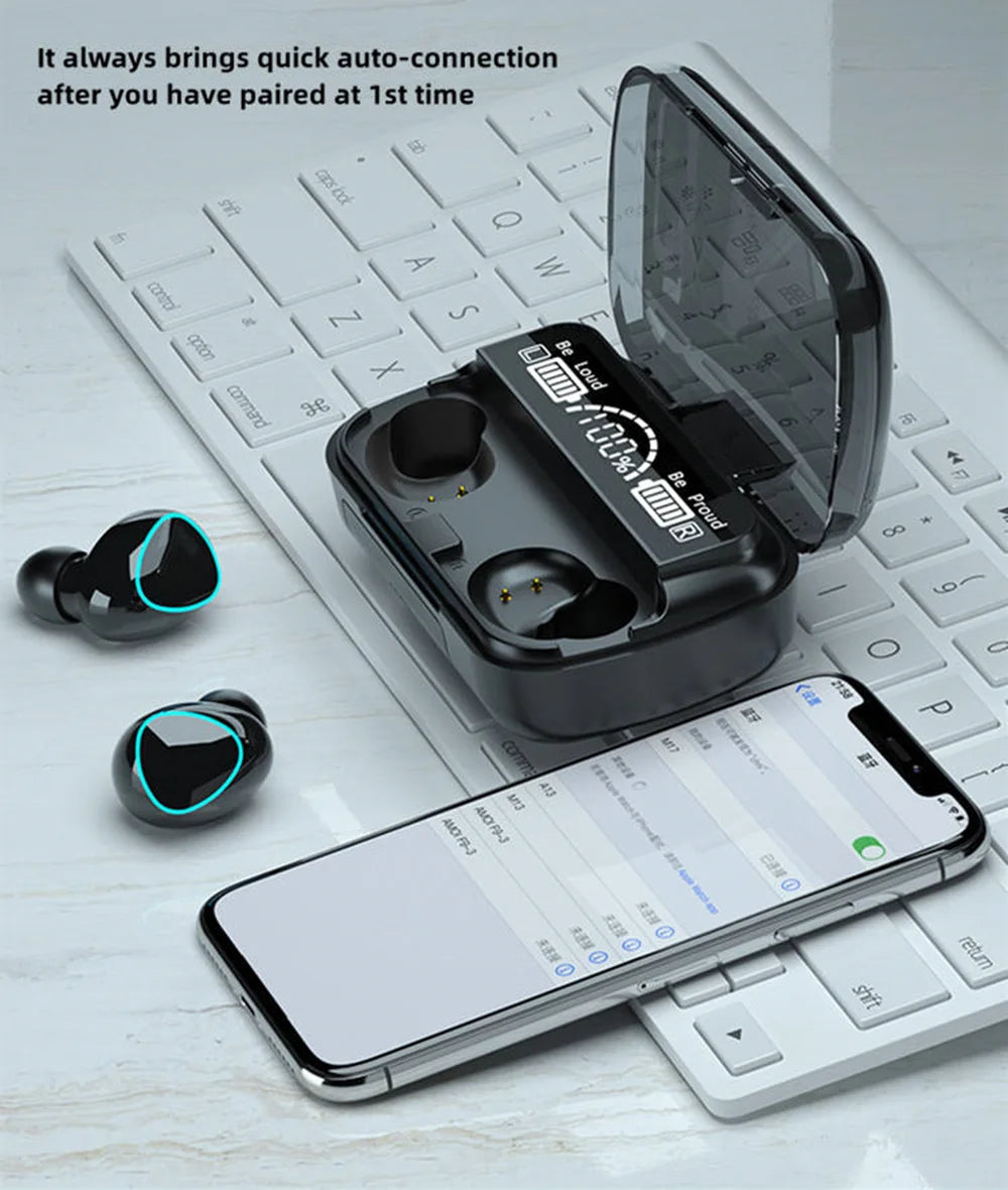 Black wireless earbuds and a charging case with a digital battery display, set on a white keyboard with a smartphone.