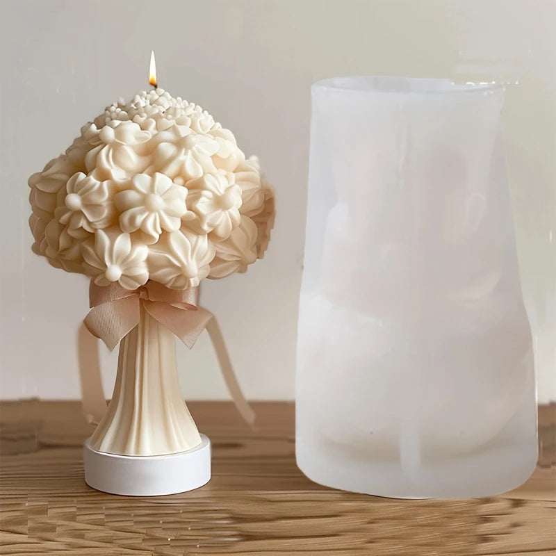 Beige 3D floral bouquet candle with a lit wick and ribbon, next to a translucent silicone mold.