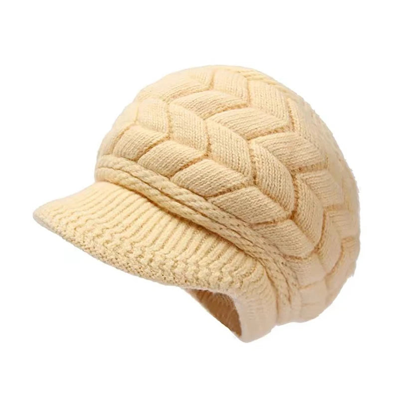 Beige thermal knitted winter cap with a textured chevron pattern, peaked brim and soft faux fur lining.