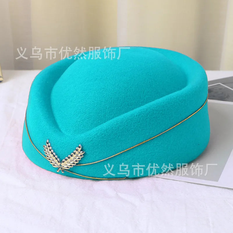 Teal vintage-style pillbox stewardess hat, featuring a gold trim and a silver laurel leaf emblem.