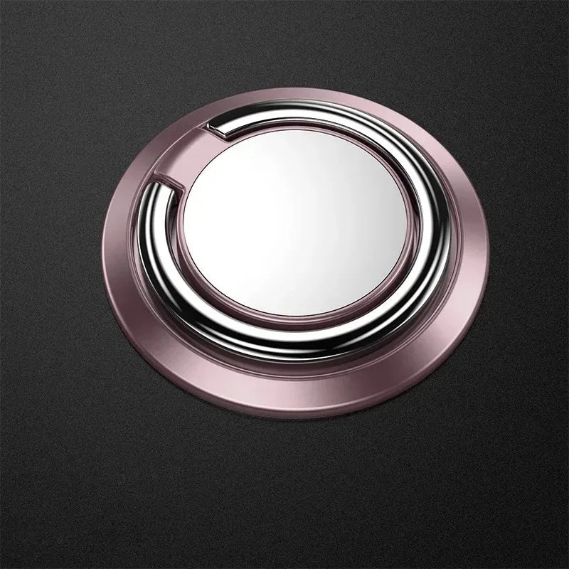 Rose gold circular phone ring holder with a polished silver rotating ring, set against a dark textured background.