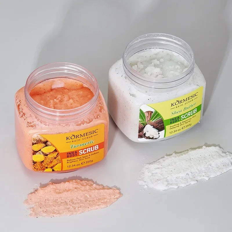 Two 350g jars of face and body scrub: one orange turmeric scrub and one white shea butter scrub on a grey background.