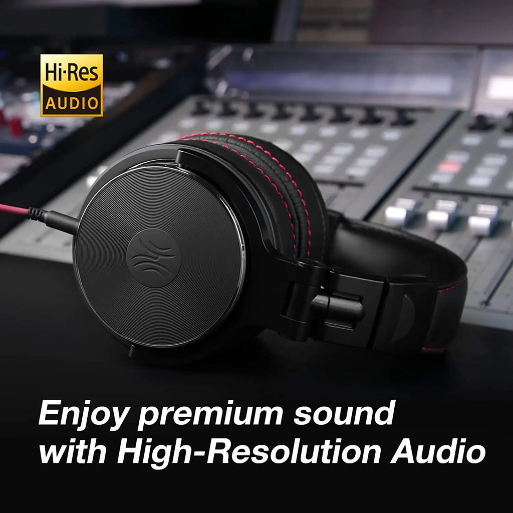 Black wired over-ear studio headphones with red stitching, featuring Hi-Res Audio certification on a mixing desk.