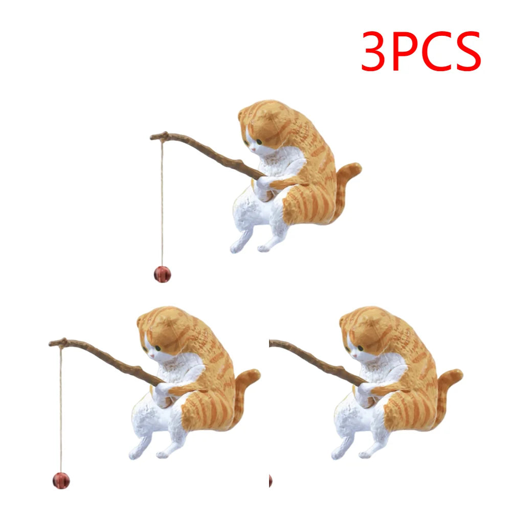 Set of three orange tabby cat aquarium ornaments, each holding a small wooden fishing rod with a hanging bead.