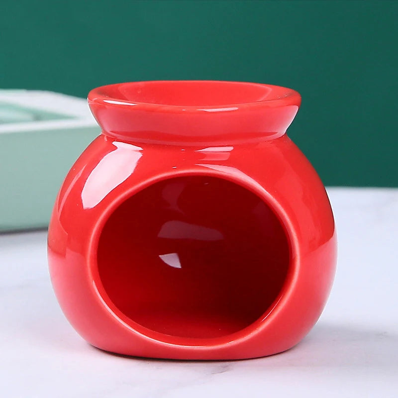 Glossy red ceramic oil burner with a rounded shape and wide front opening for a tea light candle.