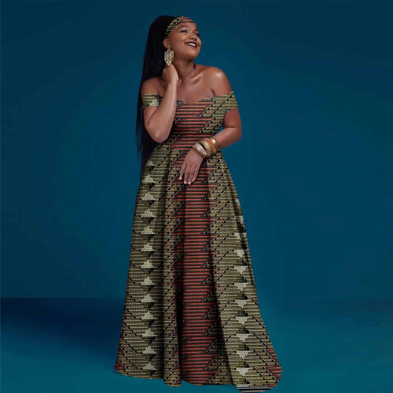 Woman wearing an off-shoulder, floor-length maxi dress with a geometric yellow, black, and orange patterned print.
