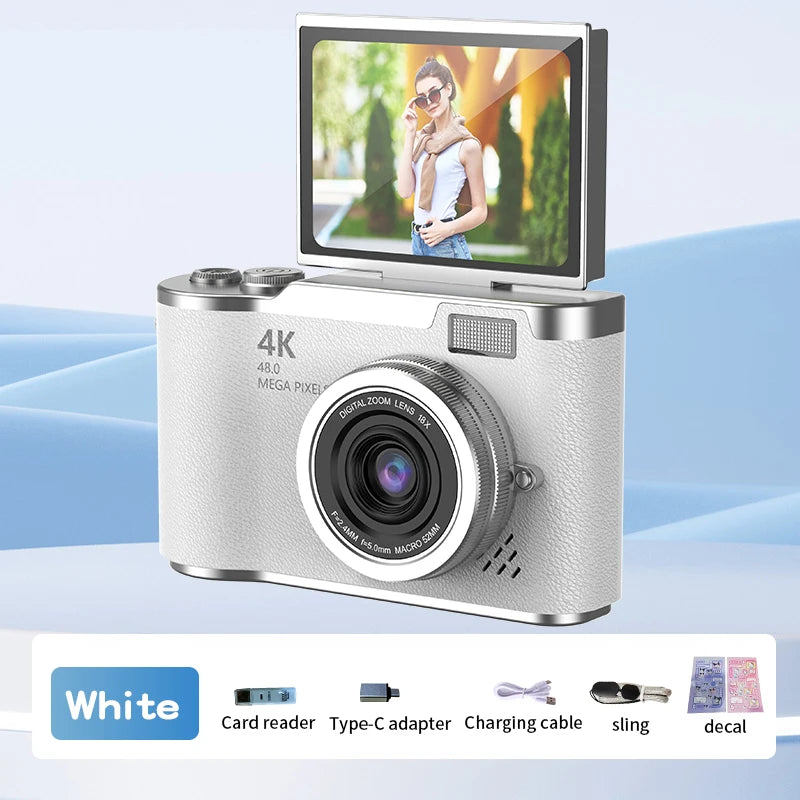 White 4K digital camera with textured finish, flip-up screen, and included accessories: cable, adapter, and stickers.
