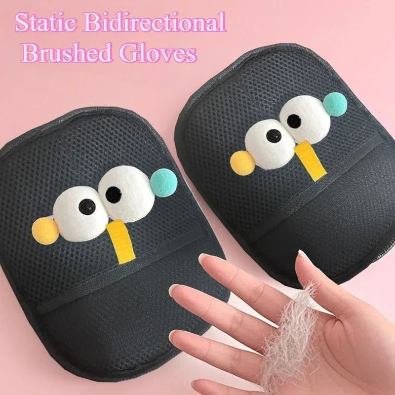 Pair of black pet hair removal gloves with playful googly eye designs, held against a soft pink background.
