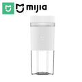 Minimalist white portable blender cup with a ribbed upper section and clear, transparent base.
