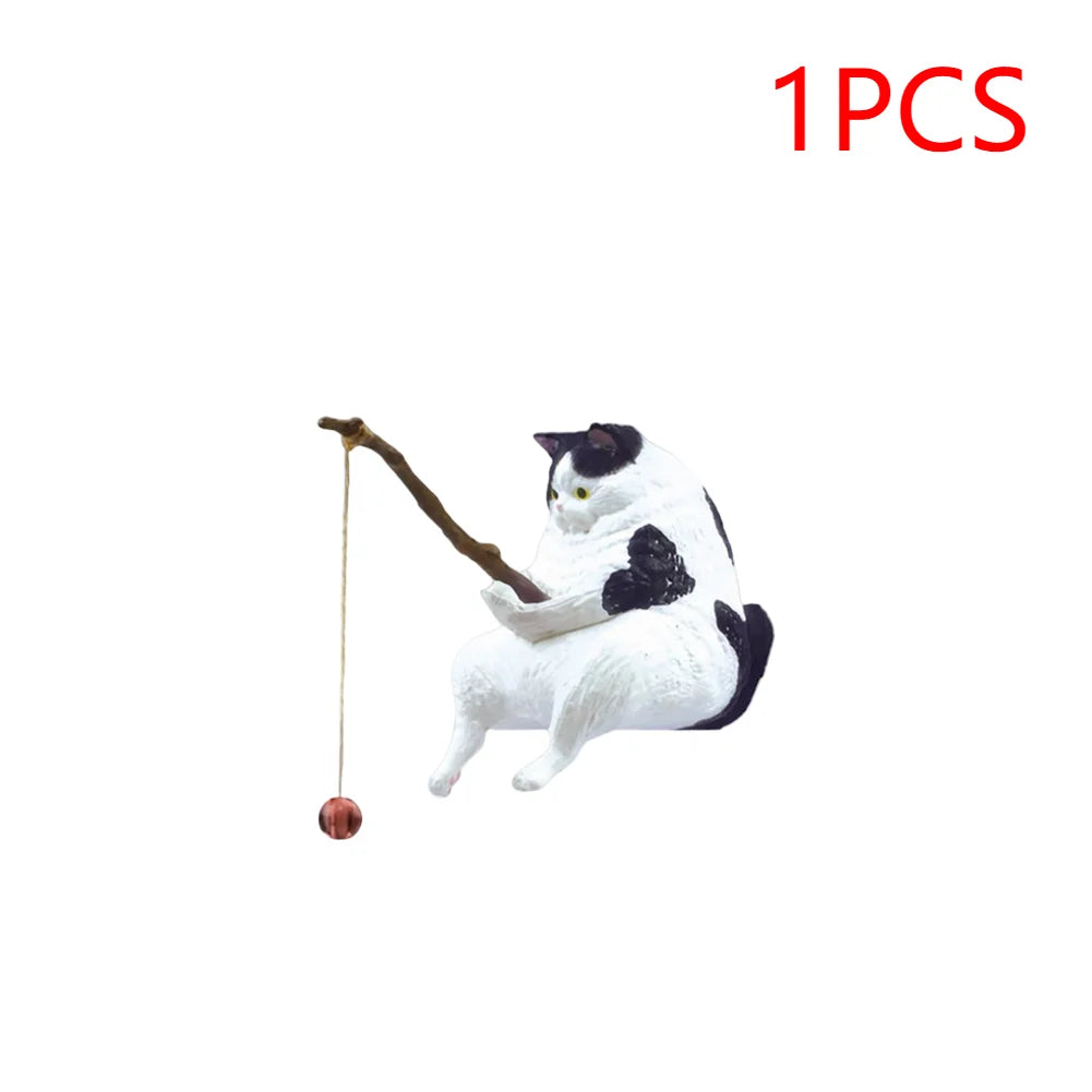A cute black and white cat ornament sitting and holding a rustic fishing rod with a dangling red bait.