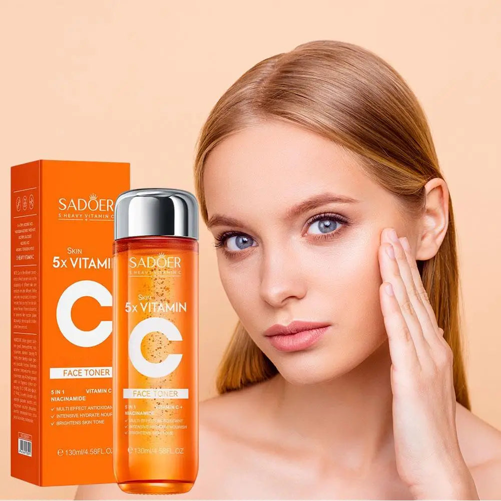 Orange bottle of 5-in-1 Vitamin C face toner with Niacinamide next to a woman applying it to her radiant skin.