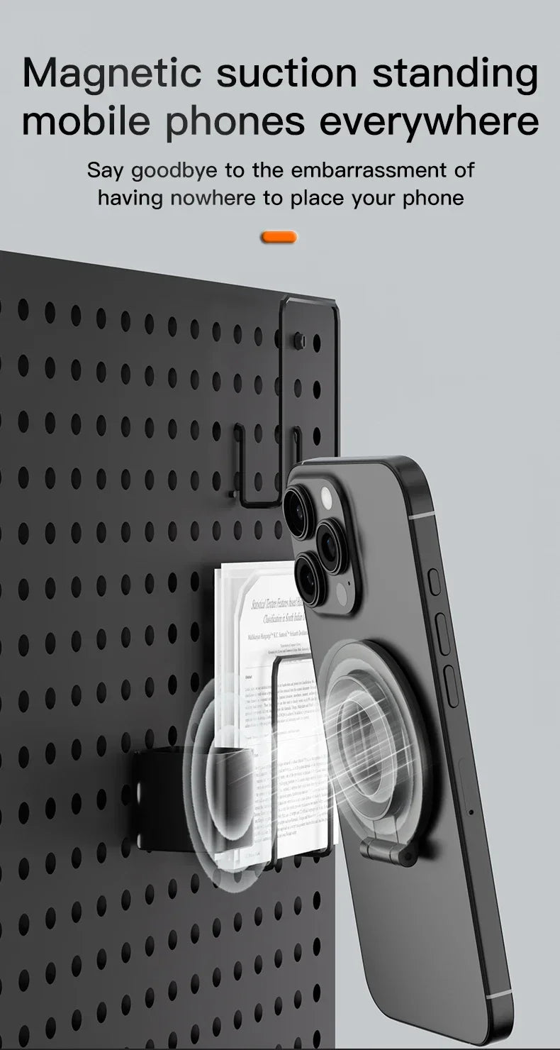 Black magnetic phone mount attached to a black pegboard, holding a smartphone with a circular magnetic stand.
