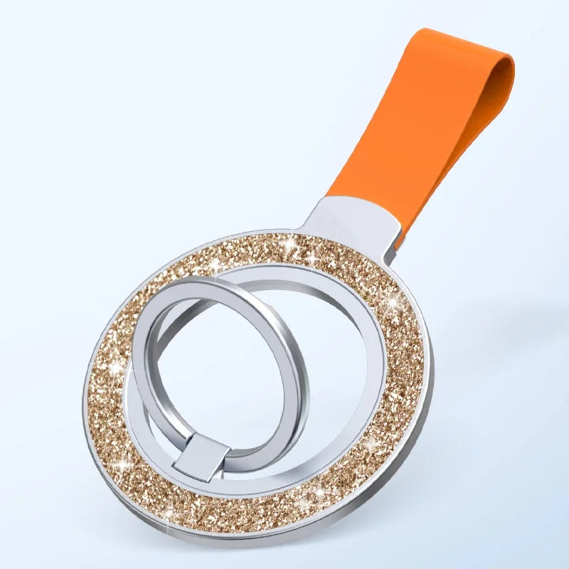 Silver phone ring holder with a sparkling gold glitter border and a vibrant orange strap on a light blue background.