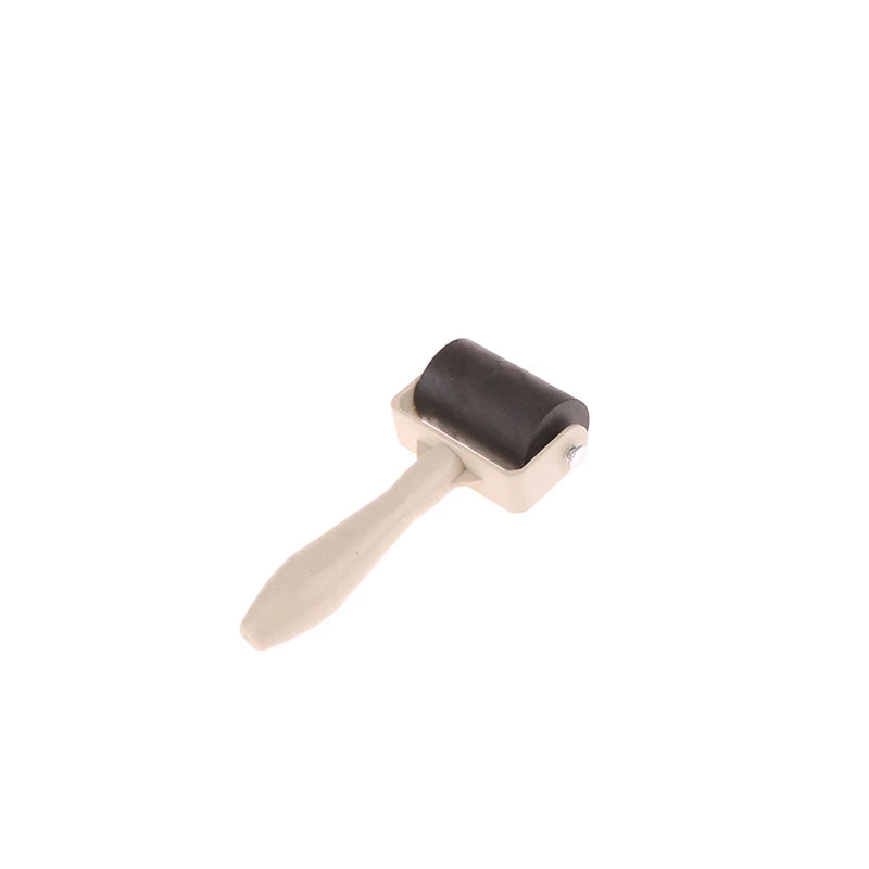 Rubber brayer roller for printmaking and crafts with a black rubber cylinder and a beige plastic handle.