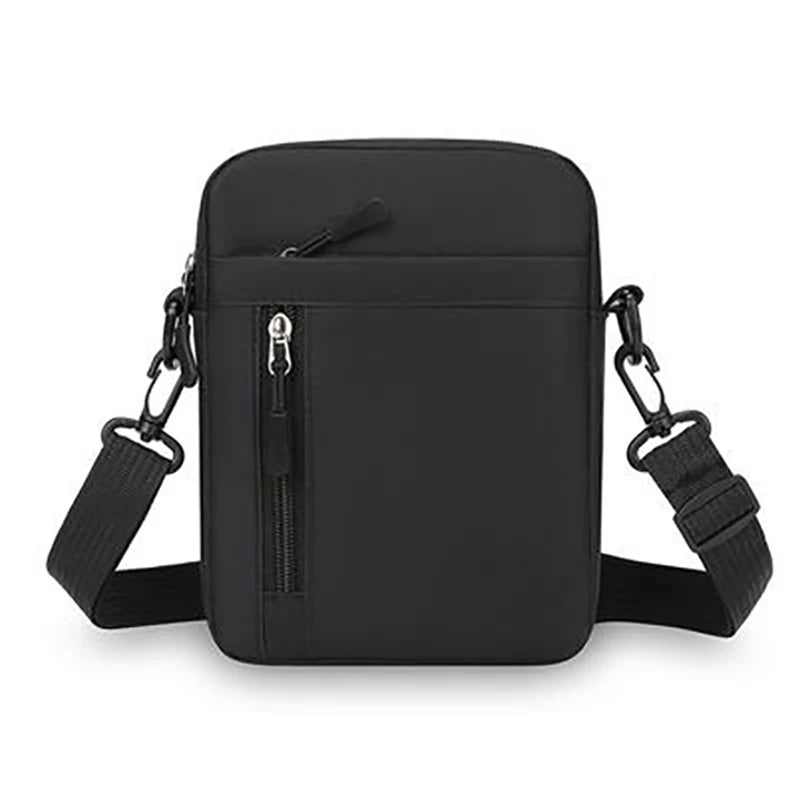 Minimalist black men’s crossbody bag with an adjustable strap, top zip closure and a vertical front zip pocket.