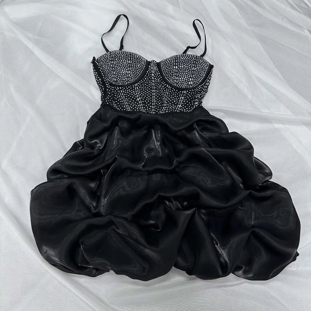 Black mini dress with rhinestone-embellished sweetheart bodice, thin straps, and ruched puff skirt.