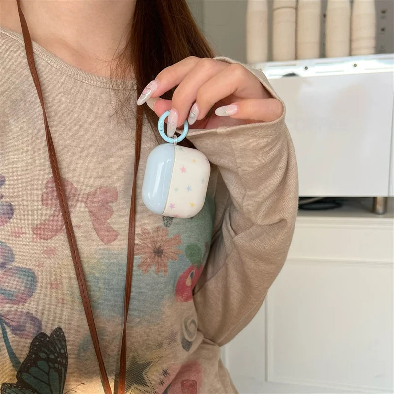 Glossy blue and white star-print silicone AirPods Pro case with a matching blue ring attachment.