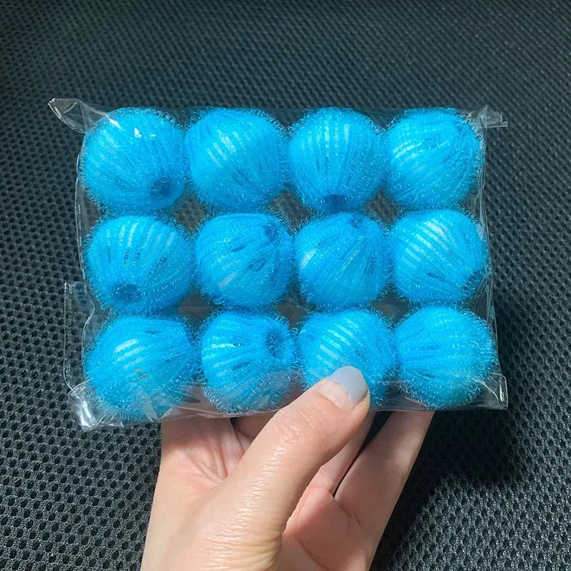A hand holding a clear plastic pack of 12 bright blue, textured spherical laundry balls.