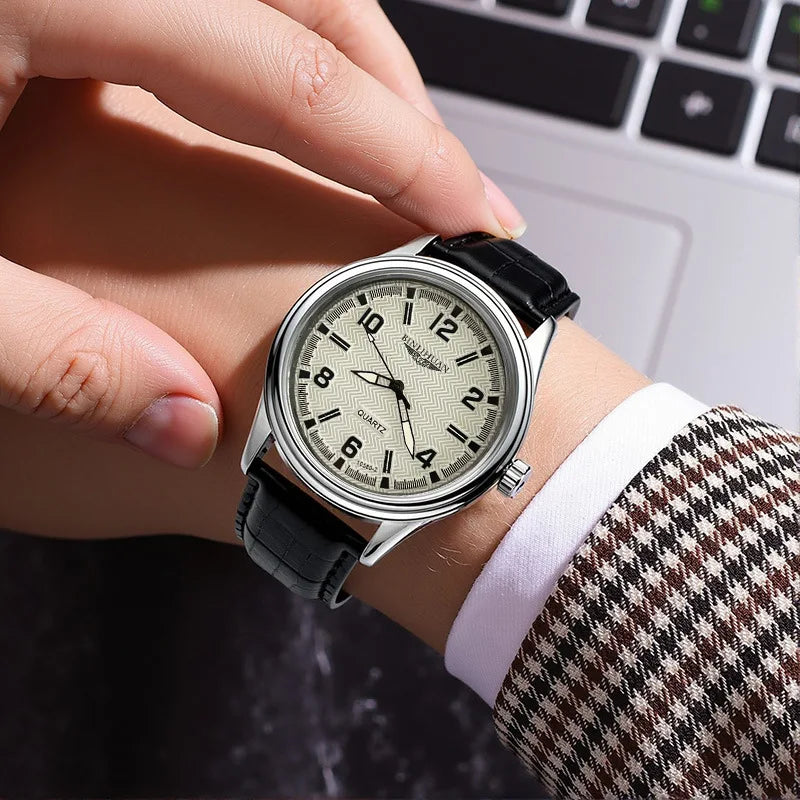 Men’s classic quartz watch with a textured cream dial, black numbers, silver case, and black leather strap.