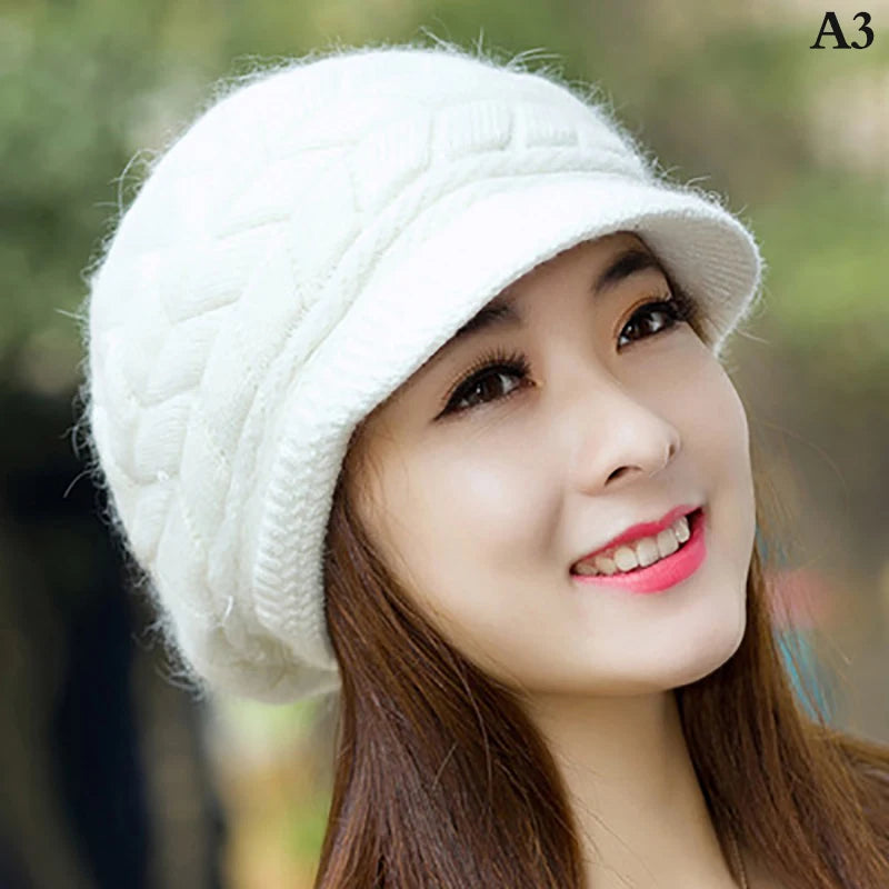 Women wearing a white, thermal knitted winter cap with a textured cable-knit pattern and a small peak.