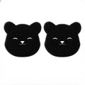 Two black, bear-shaped textured sponges with smiling faces on a plain white background.