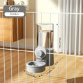 Gray pet water dispenser with a clear cylindrical bottle and a paw-print knob, attached to a wire cage.