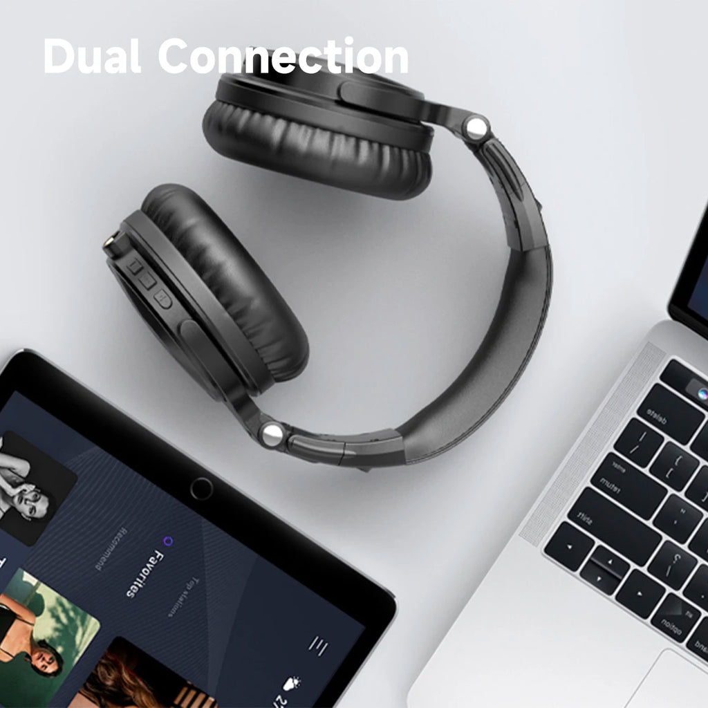 Black wireless over-ear headphones with plush ear cups, shown between a laptop and tablet to demonstrate dual connection.