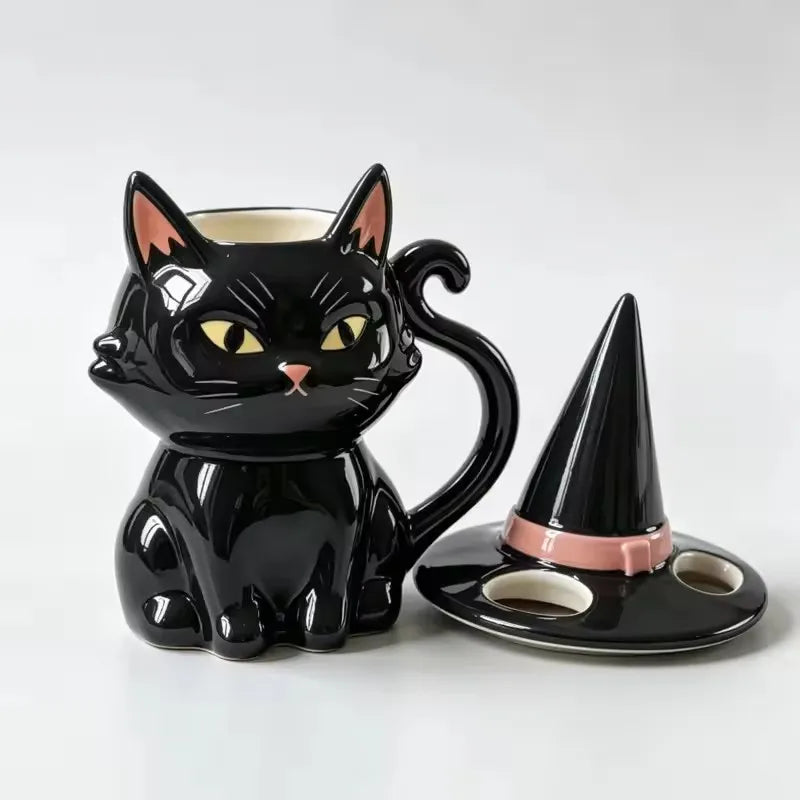 Glossy black ceramic cat mug with yellow eyes, tail handle, and a matching witch hat lid.
