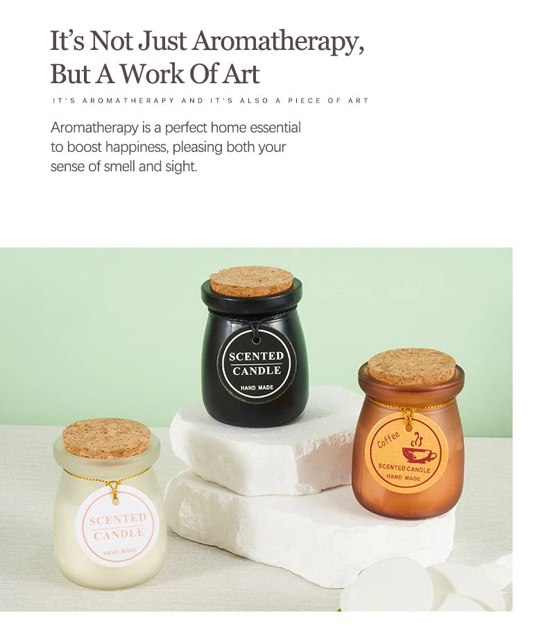 Three handmade scented candles in black, copper, and frosted glass jars with cork lids, displayed on stone platforms.