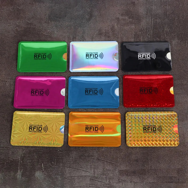 Nine multicolored, metallic RFID-blocking card protector sleeves arranged on a dark surface.