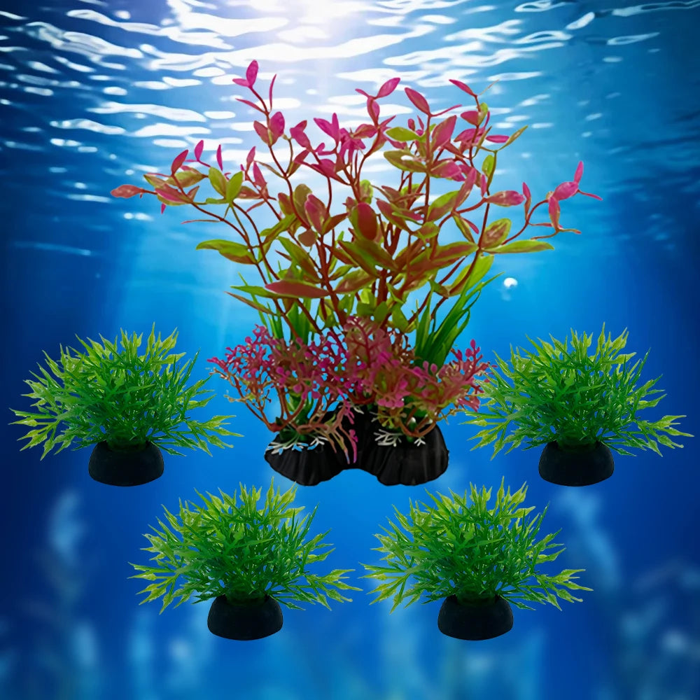 Five artificial aquarium plants including one tall pink and green stem plant and four small, bushy green grass tufts.