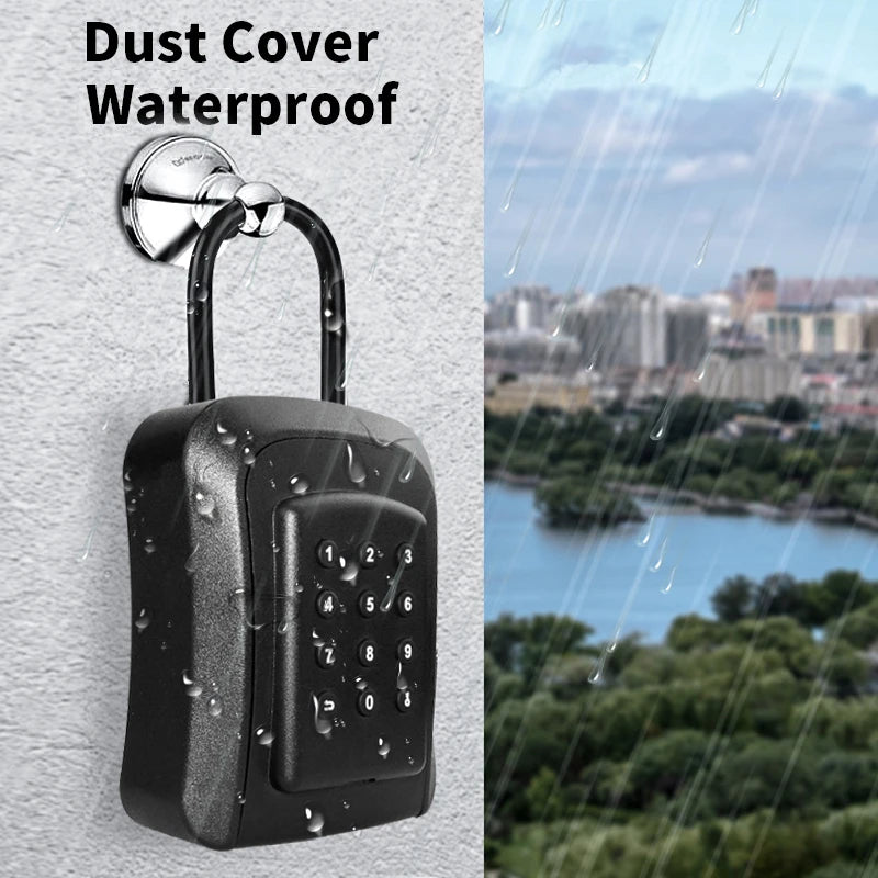 Black plastic waterproof key lock box with a push-button combination keypad, hanging on a metal hook in the rain.