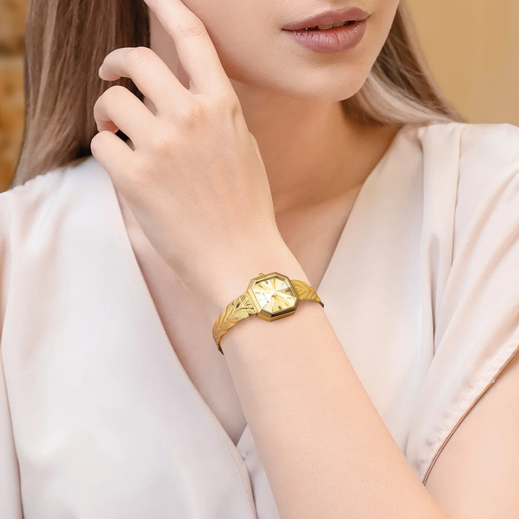 BERNY gold women's watch with an octagonal case and a textured stainless steel mesh bracelet on a wrist.